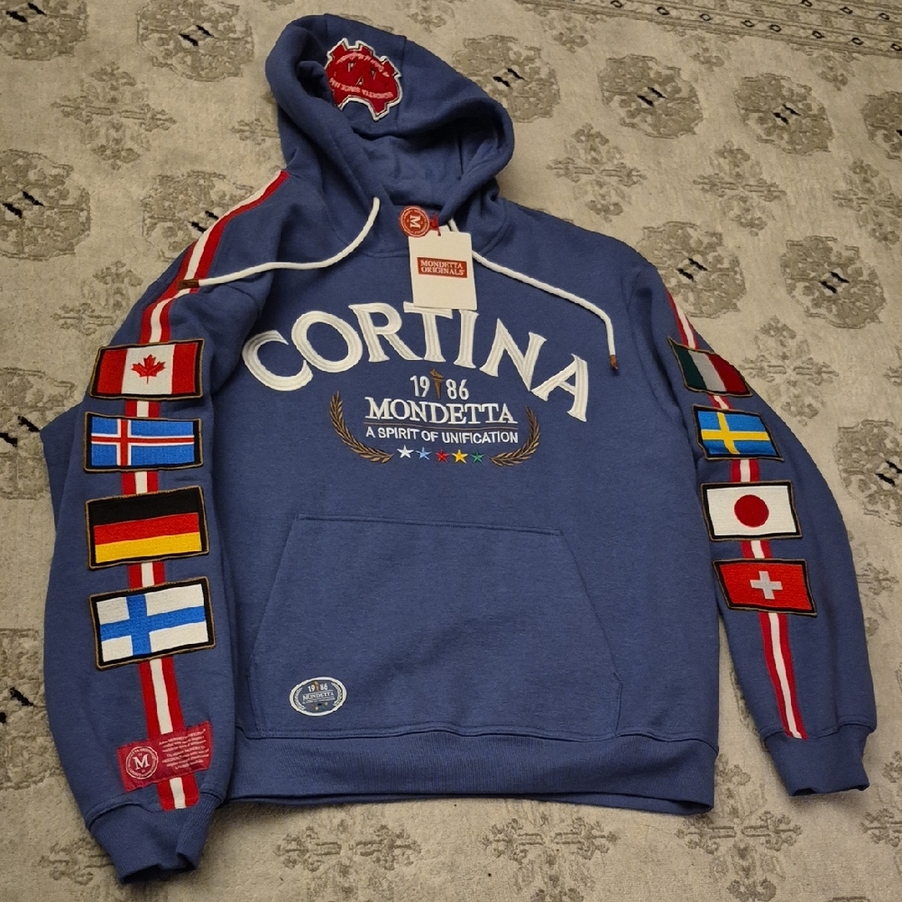 L: Mondetta Cortina Blue Hoodie with Flag Patches
